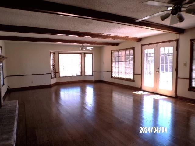 spare room featuring french doors, dark hardwood / wood-style flooring, ceiling fan, and beamed ceiling