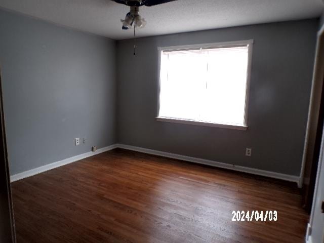 spare room with ceiling fan and dark hardwood / wood-style flooring