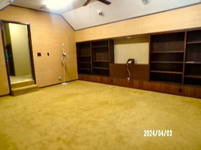 empty room with vaulted ceiling and carpet floors