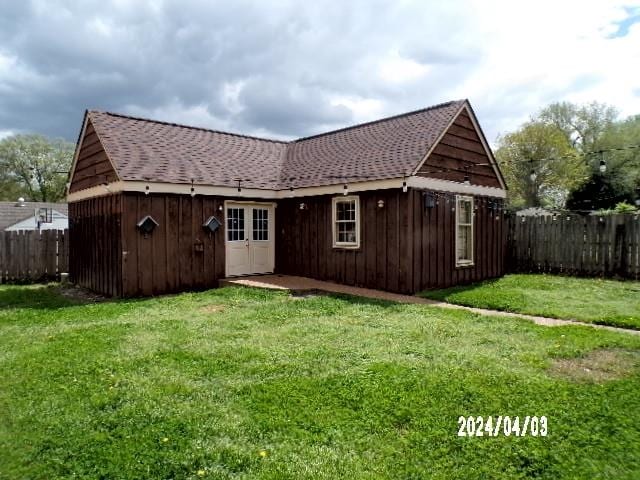 rear view of property featuring a yard