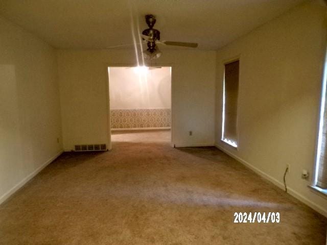 carpeted spare room with ceiling fan