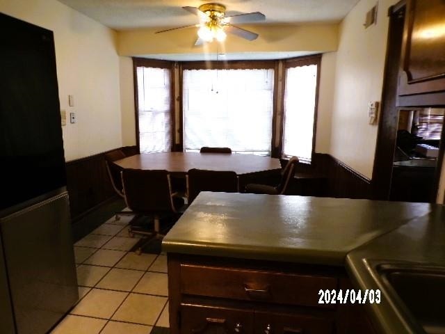 interior space with ceiling fan and light tile floors