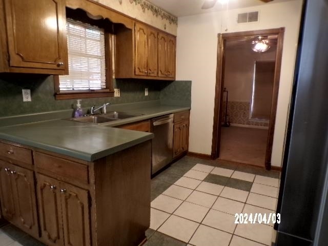 kitchen featuring sink, light carpet, and stainless steel dishwasher