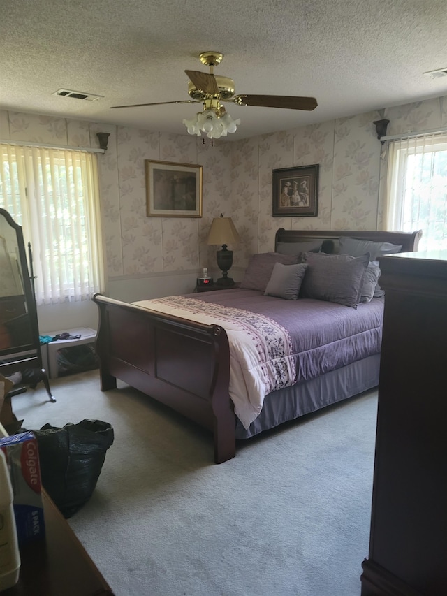 carpeted bedroom with a textured ceiling and ceiling fan