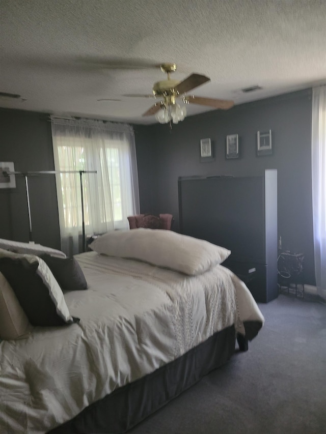 carpeted bedroom with a textured ceiling and ceiling fan