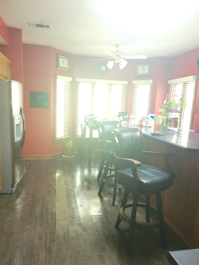 dining area featuring ceiling fan, a textured ceiling, and dark wood-type flooring