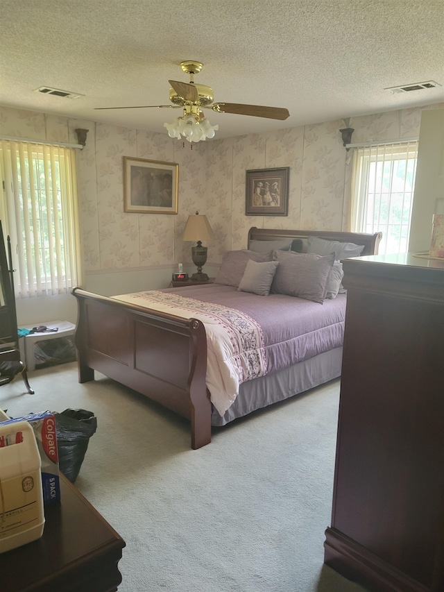 carpeted bedroom with a textured ceiling and ceiling fan