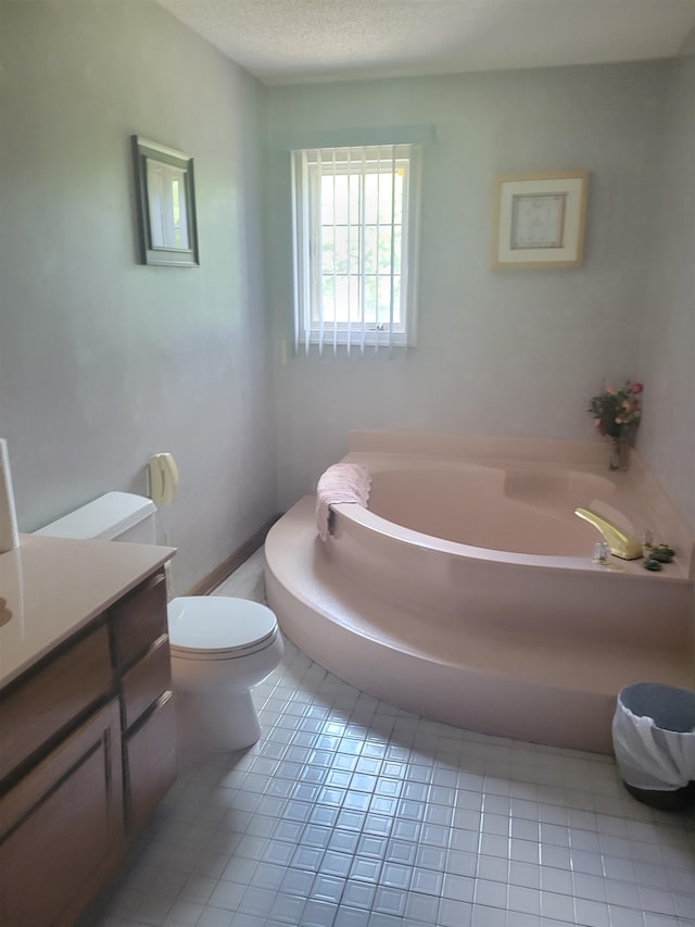 bathroom featuring toilet, a bath to relax in, vanity, a textured ceiling, and tile floors