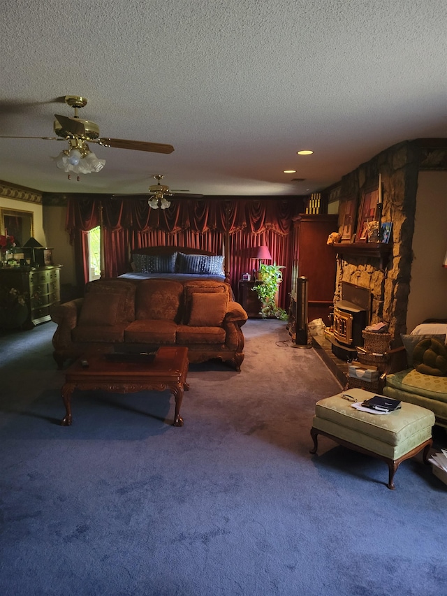 living room with a textured ceiling, carpet floors, a fireplace, and ceiling fan