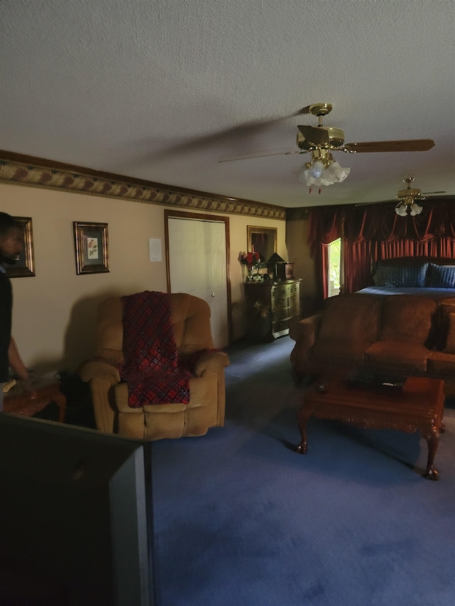 living room with ceiling fan, carpet flooring, and a textured ceiling