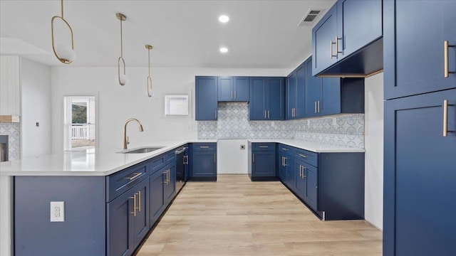 1072 Bruce St, Memphis, TN 38104 - kitchen featuring decorative light fixtures, light hardwood / wood-style floors, sink, and tasteful backsplash