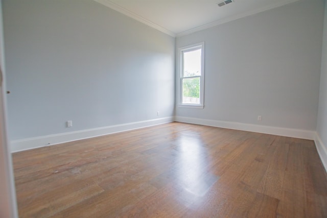 spare room featuring hardwood / wood-style flooring and crown molding