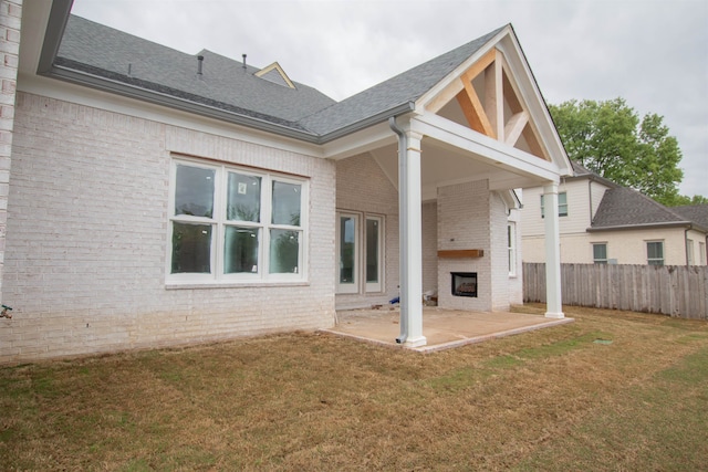 back of property with a patio area and a yard