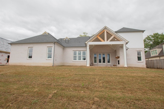 rear view of house featuring a yard