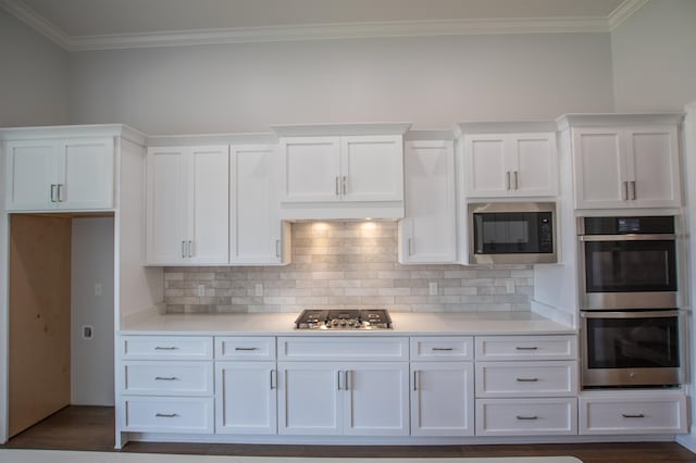 kitchen with crown molding, white cabinetry, dark hardwood / wood-style flooring, and stainless steel appliances