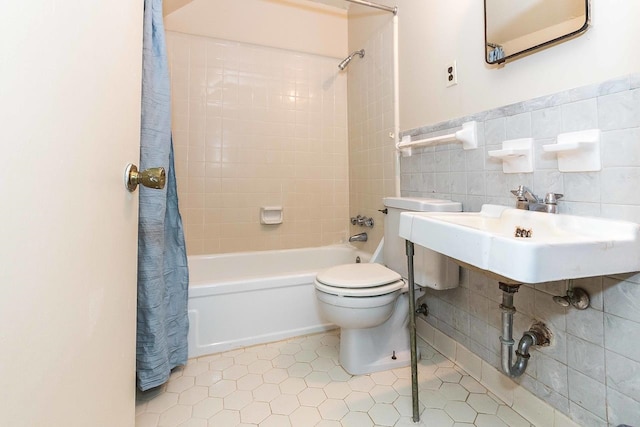 full bathroom with tile flooring, tile walls, shower / bath combo with shower curtain, backsplash, and toilet