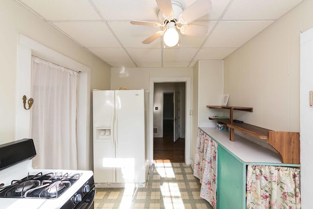 kitchen featuring ceiling fan, stove, a paneled ceiling, and white refrigerator with ice dispenser