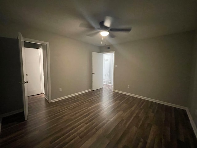 unfurnished room featuring ceiling fan and dark wood-type flooring