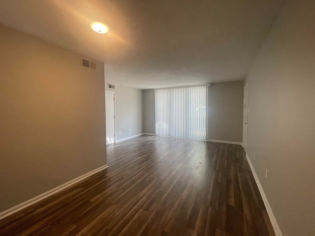 unfurnished room with dark hardwood / wood-style flooring