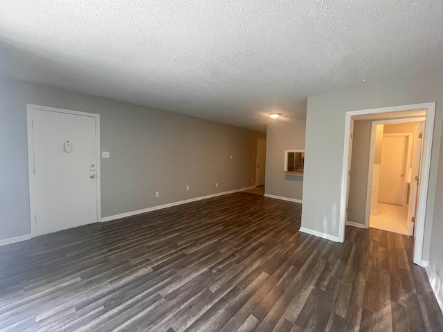 unfurnished living room featuring dark hardwood / wood-style flooring and a textured ceiling