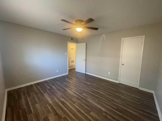 unfurnished room featuring dark wood-type flooring and ceiling fan