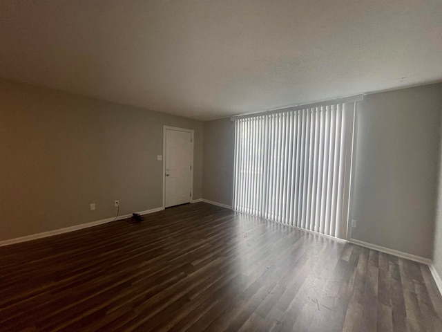 empty room featuring dark wood-type flooring