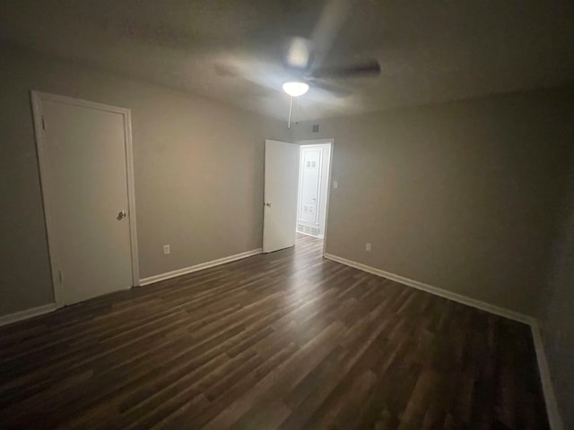 spare room with dark hardwood / wood-style flooring and ceiling fan