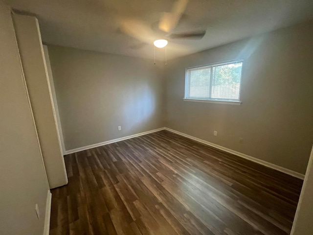 empty room with ceiling fan and dark hardwood / wood-style floors