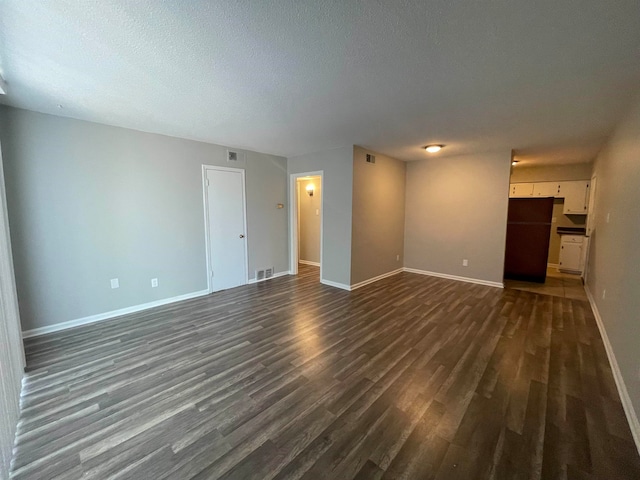 unfurnished room featuring dark hardwood / wood-style floors and a textured ceiling