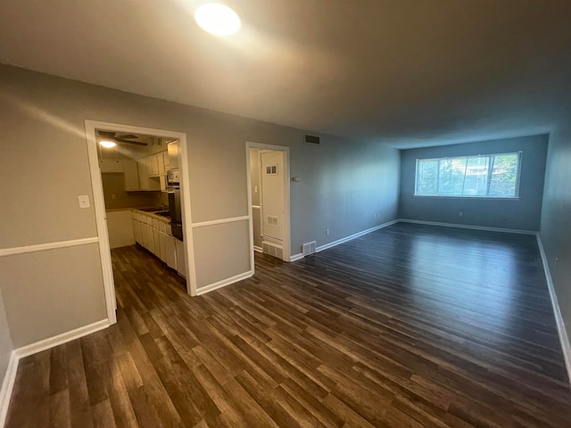 unfurnished living room with dark wood-type flooring and ceiling fan