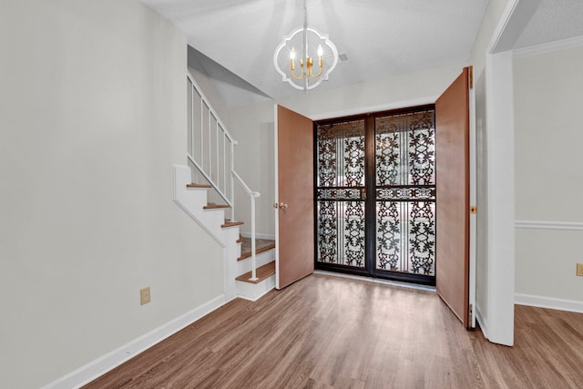 entryway featuring a chandelier, light hardwood / wood-style floors, and a textured ceiling