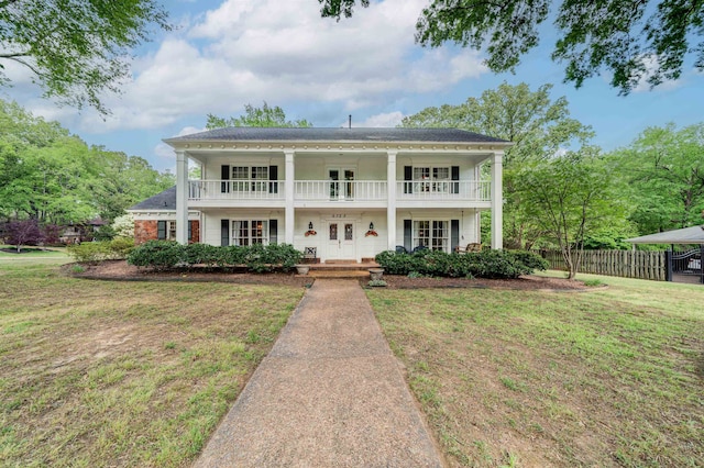 view of front of house featuring a front yard and a balcony