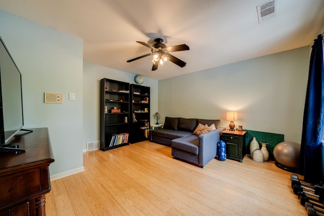 living room featuring light hardwood / wood-style flooring and ceiling fan