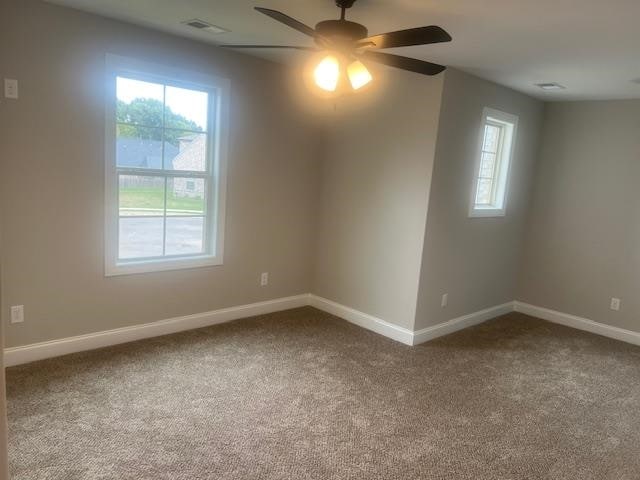 carpeted empty room featuring ceiling fan