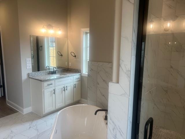 bathroom with tile walls, a tub to relax in, and vanity