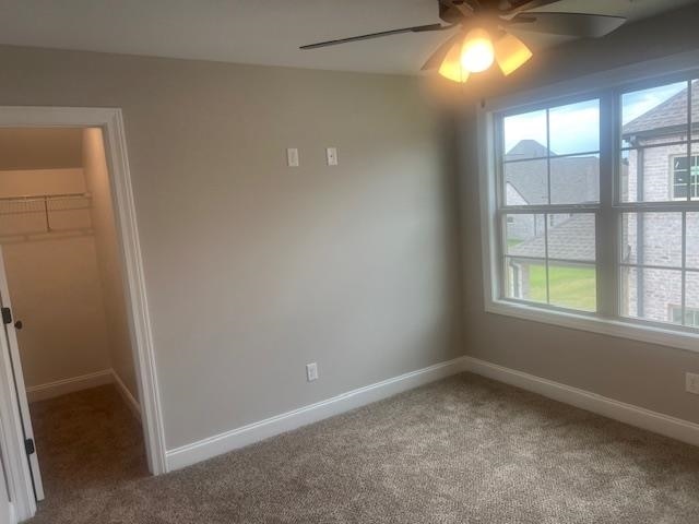 unfurnished room with carpet and ceiling fan