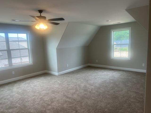 bonus room with carpet flooring, ceiling fan, and plenty of natural light