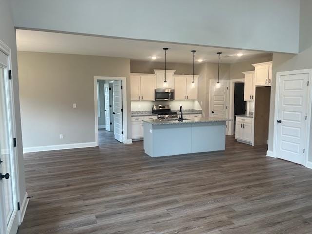 kitchen featuring white cabinets, a kitchen island with sink, dark hardwood / wood-style floors, and stainless steel appliances