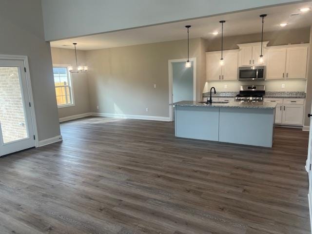 kitchen with stainless steel appliances, white cabinets, decorative light fixtures, and dark hardwood / wood-style flooring