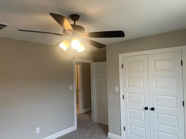 unfurnished bedroom featuring light carpet, a closet, and ceiling fan