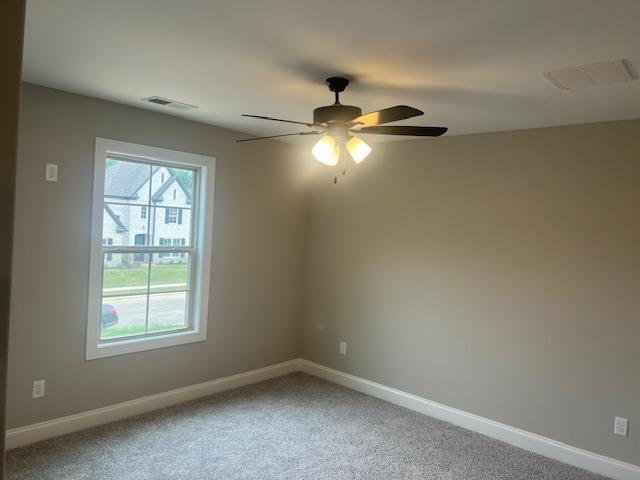 carpeted spare room with ceiling fan