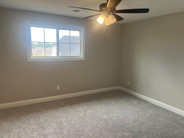 spare room featuring ceiling fan and carpet