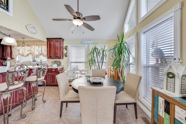 tiled dining area featuring a healthy amount of sunlight and high vaulted ceiling