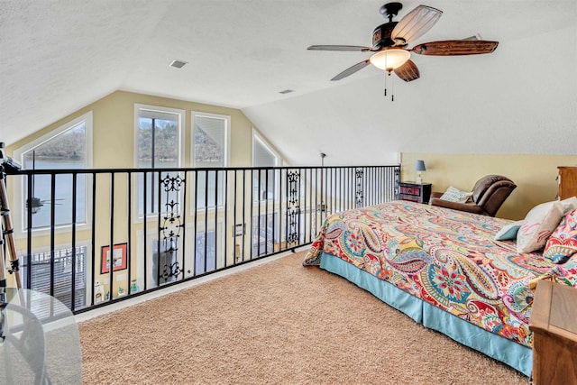 carpeted bedroom with ceiling fan, a textured ceiling, and vaulted ceiling