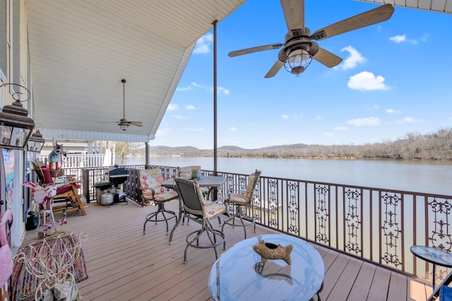 wooden terrace with ceiling fan and a water view