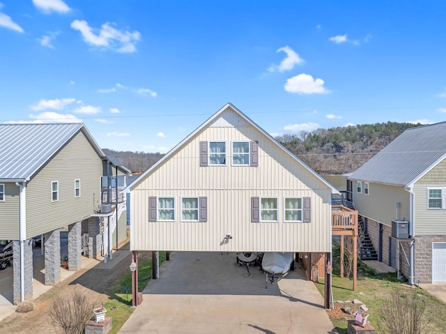 rear view of property with central AC and a carport