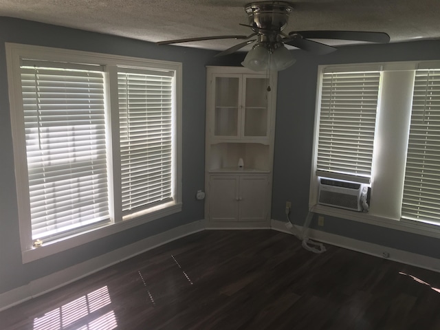 unfurnished room with ceiling fan, dark hardwood / wood-style floors, and a textured ceiling