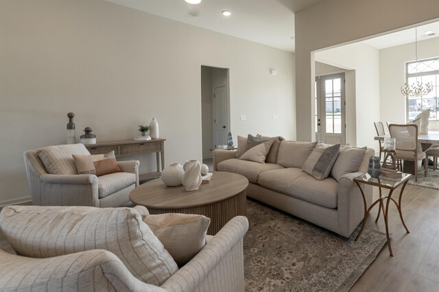 living room featuring a notable chandelier and light wood-type flooring