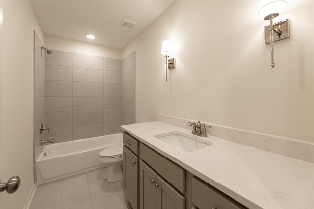 full bathroom featuring tiled shower / bath, tile patterned floors, vanity, and toilet