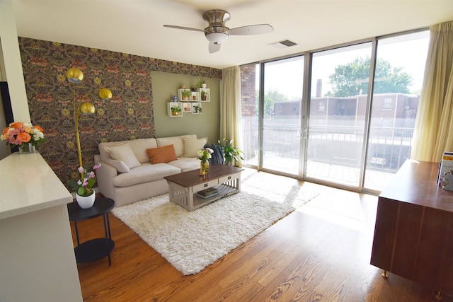 living room with hardwood / wood-style floors, ceiling fan, and a wealth of natural light